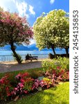 Two people sitting on a bench looking at the lake, Bellagio, Province of Como, Lake Como, Italian Lakes, Lombardy, Italy, Europe