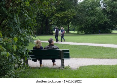 Two People Sitting Quietly On A Bench