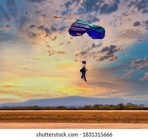 two people skydiving in tandem with a blue parachute