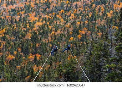 Two People Sliding Down Very Long And Fast Zipline During Autumn In Stowe, Vermont