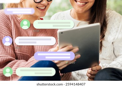 Two people smiling, using a tablet, with chat bubbles overlay. They are engaged, enjoying a conversation. Technology and communication are key themes. Business and technology image.
