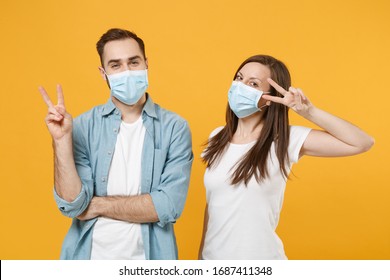Two people in sterile face masks white t-shirts isolated on yellow background studio. Epidemic pandemic rapidly spreading coronavirus 2019-ncov medicine flu virus ill sick disease treatment concept - Shutterstock ID 1687411348