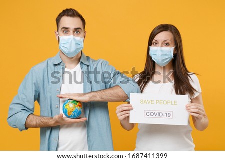 Two people in sterile face masks hold globe infographic isolated on yellow background studio. Epidemic pandemic rapidly spreading coronavirus 2019-ncov medicine flu virus ill sick treatment concept
