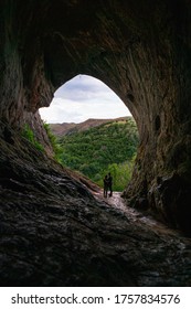 Two People Stood In Thors Cave Looking At The View In The Peak District 