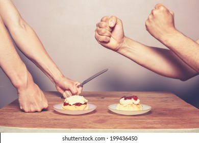 Two People At Table Are Fighting Over How To Make The Perfect Cream Tea