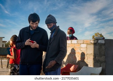 Two People Talking Business In An African Village In A Summer Day