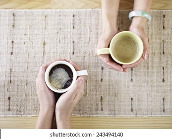 two people talking while drinking coffee.