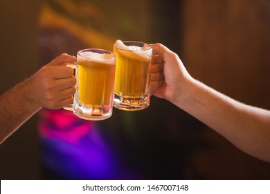 Two People Toasting With Mugs Full Of Chopp