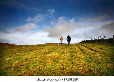 Two People Walk Up Hill in the Distance