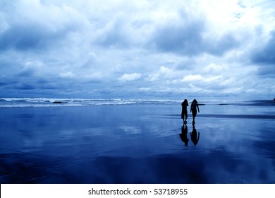 Two People Walking At A Beach