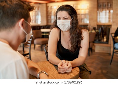 Two People Wearing Surgeon Masks Is Sitting In A Cafe And Chatting Her Friend. Health Measures For Covid 19 And Corona In The Community. Woman Wearing Mask, Sitting A Cafe With Her Friend.