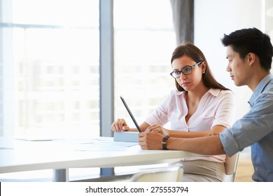 Two People Working With Digital Tablet In Empty Meeting Room