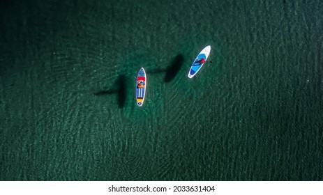 Two peoples are walking on sup boards aerial view - Powered by Shutterstock