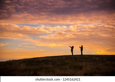 two peoples's shape shadow under the orange clouds