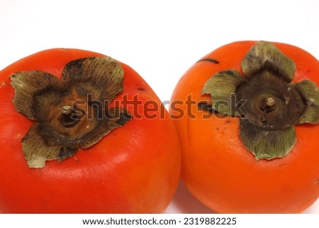 two persimmons on white background. Fruit details. orange colored fruits.
