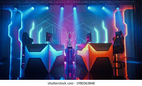 Two Person Empty Computer Gaming eSports Championship Arena with Winner Trophy Standing on a Stage. Stylish Online Live Streaming Tournament with Big Screens Showing Graphics and Neon Stage