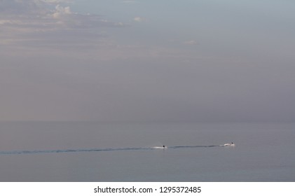 Two Personal Water Craft Cut Across A Perfectly Still Ocean