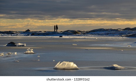 Two persons looking into the future by the frozen sea