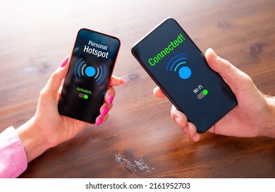 Two persons sharing internet between their phones by using personal hotspot feature - Shutterstock ID 2161952703