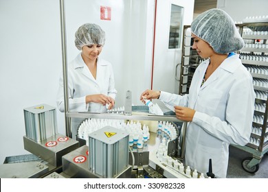 Two Pharmaceutical Factory Workers At Pharmacy Industry Manufacture Checking Medicine On Conveyer 