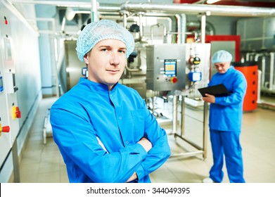 Two Pharmaceutical Technician Male Workers Operating Water Preparation Production Line At Pharmacy Industry Manufacture Factory Using Notebook Computer