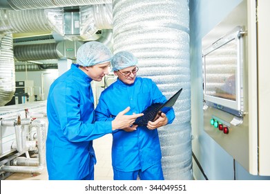 Two Pharmaceutical Technician Male Workers In Air Conditioning Production Line Hall At Pharmacy Industry Manufacture Factory Using Notebook Computer