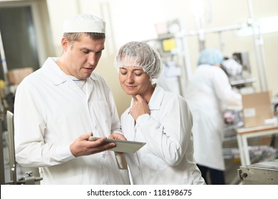 Two Pharmaceutical Workers Discussing Manufacture Project With Tablet Computer At Pharmacy Industry