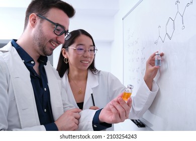 Two Pharmacist Researchers Comparing Two Medicine Vials.