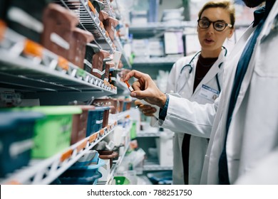 Two pharmacists checking inventory at hospital pharmacy. Hospital staff stocktaking in drugstore. - Powered by Shutterstock