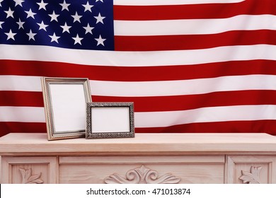 Two Photo Frames With USA Flag On Wooden Mantelpiece