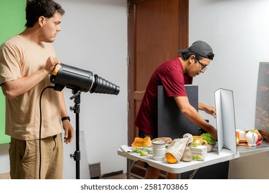 Two photographers preparing lighting and composition for a product photo shoot in a professional studio