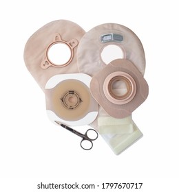 Two piece ostomy appliances including flanges, pouches and scissor isolated a a white background