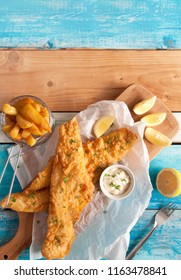 Two Pieces Of Fried Fish In Batter With Chips In A Serving Basket 