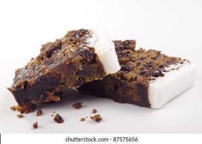 Two Pieces Of Iced Fruit Cake And A White Background