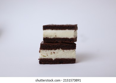 Two pieces on top of each other from a side of Kinder milk slice on a white background cake bottom with milk vanilla mousse