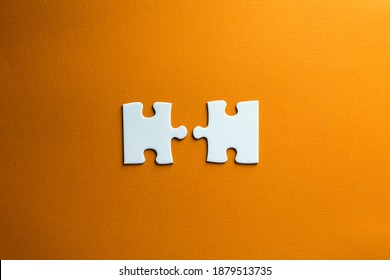 A Two Pieces Of A Puzzle Do Not Fit Together. White Pieces On An Orange Background. Conceptual Photo Of Problems Derived From Work And Social Life