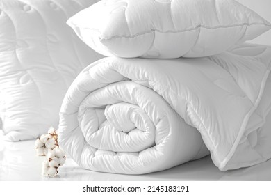 Two pillows and a folded blanket on a white background. Bedding items on a white background. Bedding catalog