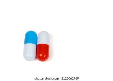 Two Pills Isolated On White Background. Blue And Red Capsules. Medical Concept. The Issue Of Drug Choice. Copy Space.