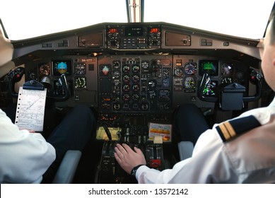 Two Pilots In Cockpit Of Plane During Mountain-flight