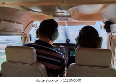 Two pilots sitting in a cockpit of cessna skyhawk 172 airplane.