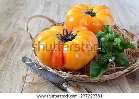 Two pineapple tomatoes, basil and vintage knife