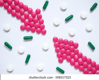 Two Pink Arrows Made By Pills With Different Pills/capsules On White Background. Creative Idea For Drug Comparisons, Drug Interaction, Side Effect And Pharmacy Development Concept. Medicine Theme.