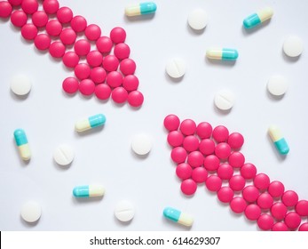 Two Pink Arrows Made By Pills With Different Pills/capsules On White Background. Creative Idea For Drug Comparisons, Drug Interaction, Side Effect And Pharmacy Development Concept. Medicine Theme.