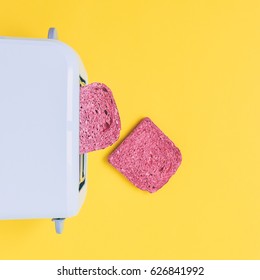 two pink toast springing from the toaster on a yellow background. fashion food of breakfast.