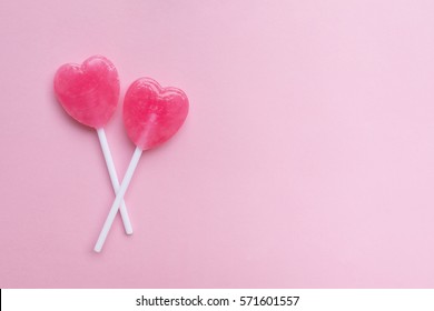 Two Pink Valentine's Day Heart Shape Lollipop Candy On Empty Pastel Pink Paper Background. Love Concept. Top View. Minimalism Colorful Hipster Style.