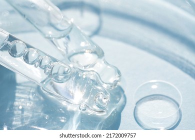 Two pipettes with transparent cosmetic liquid over blue background with copy space. Texture of face serum or cosmetic oil, beaty treatment. Selective focus - Shutterstock ID 2172009757