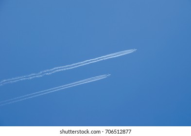 Two planes flying in parallel, leaving behind a white trail.