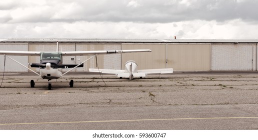 Two planes parked one facing forward and one back