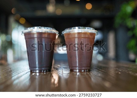 Two of plastic cup of cold brew americano on wood table