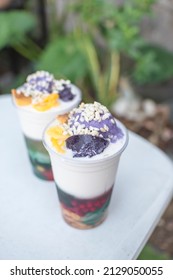 Two plastic cups of Halo-halo, a popular cold dessert in the Philippines, at an outdoor or al fresco cafe. Refreshing local snack. - Shutterstock ID 2129050055